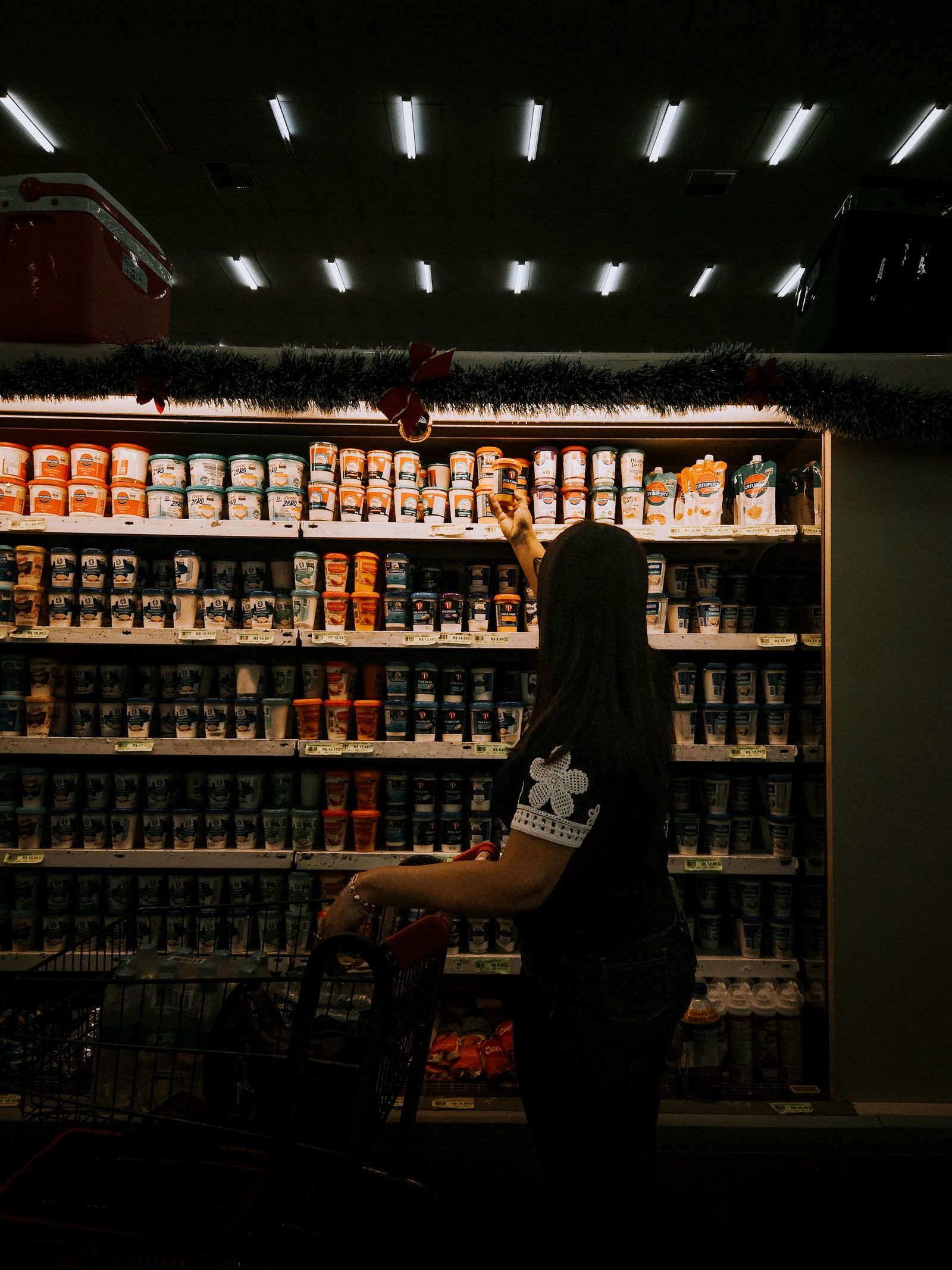 Shopper comparing items in a grocery aisle